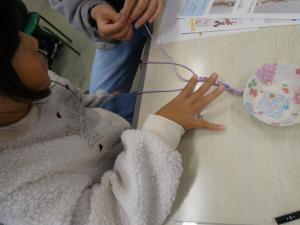 親子で紐にビーズを通している写真