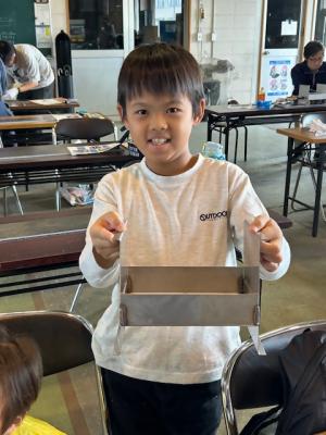 完成したミニバーベキューグリルを持って喜んでいる参加者