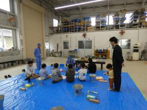 指導員の説明を聞く参加者の全体写真