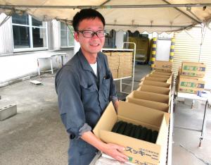 初出荷のズッキーニを手に取る新規栽培者