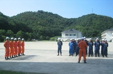 指導教官の前で学生が整列しています。